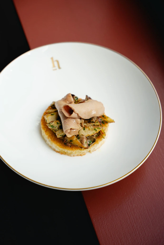 House dish on a white plate with a gold rim, served at Brabohoeve